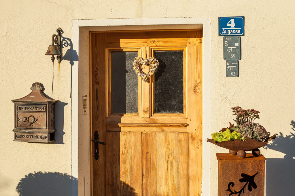 Die Haustür aus Holz mit Briefkasten und Deko