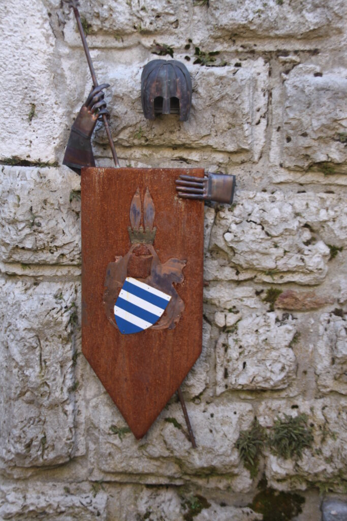 Schild/Wappen mit Metallritter an Steinwand